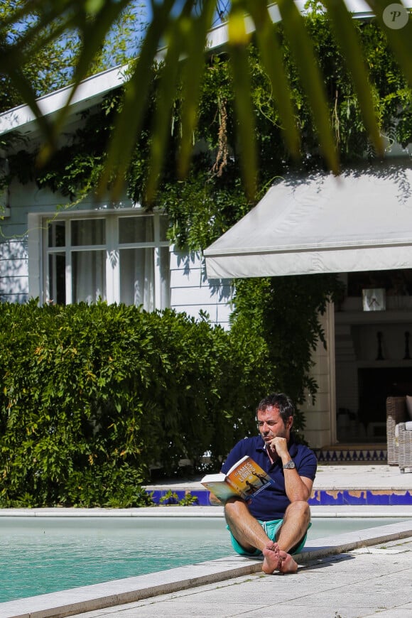 Bernard Montiel, présentateur et animateur radio pose dans sa maison du Pyla au bord de sa piscine. Après avoir joué l'expert-media dans le jeu "La télé même l'été, Le jeu" sur C8, il passe ses vacances chez lui à Pyla-sur-Mer, son refuge depuis 30 ans. Toujours entouré des oeuvres de son grand ami Richard Orlinski, Bernard aime y recevoir ses amis autour d'un dîner et une partie de pétanque....loin du tumulte parisien ! Son adresse favorite pour manger reste l'hôtel-restaurant La Corniche, au pied de la célèbre dune du Pyla, à deux pas de chez lui, en compagnie de Sophie, la propriétaire. Il sera de retour le 28 août sur l'antenne de MFM Radio, de 9h à 12h tous les jours, et un grand retour à TPMP nouvelle version, témoignage de sa grande fidélité et amitié pour C.Hanouna. Depuis 7 ans, Bernard poursuit ses entretiens sur la chaîne TV "Animaux", où il reçoit une personnalité chaque mois qui raconte sa passion pour nos fidèles compagnons à 4 pattes. La Teste-de-Buch Pyla-Sur-Mer, le 14 juillet 2017. © Thibaud Moritz / Bestimage