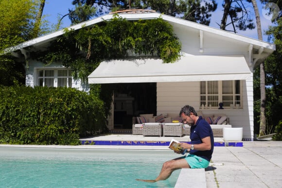 Bernard Montiel, présentateur et animateur radio pose dans sa maison du Pyla au bord de sa piscine. Après avoir joué l'expert-media dans le jeu "La télé même l'été, Le jeu" sur C8, il passe ses vacances chez lui à Pyla-sur-Mer, son refuge depuis 30 ans. Toujours entouré des oeuvres de son grand ami Richard Orlinski, Bernard aime y recevoir ses amis autour d'un dîner et une partie de pétanque....loin du tumulte parisien ! Son adresse favorite pour manger reste l'hôtel-restaurant La Corniche, au pied de la célèbre dune du Pyla, à deux pas de chez lui, en compagnie de Sophie, la propriétaire. Il sera de retour le 28 août sur l'antenne de MFM Radio, de 9h à 12h tous les jours, et un grand retour à TPMP nouvelle version, témoignage de sa grande fidélité et amitié pour C.Hanouna. Depuis 7 ans, Bernard poursuit ses entretiens sur la chaîne TV "Animaux", où il reçoit une personnalité chaque mois qui raconte sa passion pour nos fidèles compagnons à 4 pattes. La Teste-de-Buch Pyla-Sur-Mer, le 14 juillet 2017. © Thibaud Moritz / Bestimage