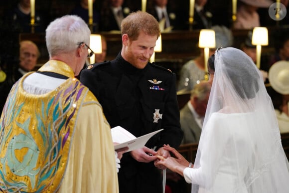 Un bijou précieux, en hommage à sa défunte mère, Lady Diana...
Le prince Harry passe l'alliance au doigt de Meghan Markle dans la chapelle St George du château de Windsor pendant leur cérémonie de mariage, dirigée par l'archevêque de Canterbury Justin Welby. Windsor, Royaume-Uni, le samedi 19 mai 2018. Le crédit photo doit être lu comme suit : Jonathan Brady/PA Wire /ABACAPRESS.COM