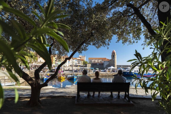 Collioure (66), touristes assis sur un banc pres du port. En arriere plan la ville et l'eglise Notre Dame des Anges - Photo by Lacombe L/ANDBZ/ABACAPRESS.COM