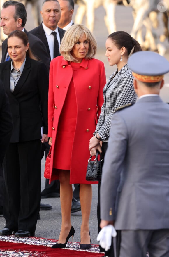 Dès son arrivée à l'aéroport de Rabat-Salé, Brigitte Macron a fait sensation avec son somptueux manteau rouge cintré, évoquant subtilement les couleurs du drapeau marocain, a notamment notifié le média "Maroc Hebdo".
Brigitte Macron - Cérémonie d'accueil officielle du Président de la République, Emmanuel Macron et de Brigitte Macron sur la place Mechouar à Rabat au Maroc le 28 octobre 2024. © Dominique Jacovides/Bestimage 