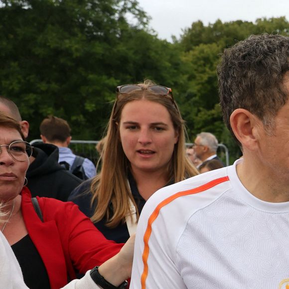 Dany Boon passe devant des agents de la police nationale - Dany Boon, dernier porteur de la flamme olympique dans le Nord, a allumé le chaudron olympique sur l'esplanade du Champs de Mars à Lille le 2 juillet 2024.