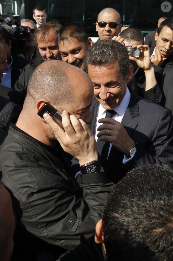 Nicolas Sarkozy s'est rendu à Tremblay (93) le 20 avril 2010 pour visiter les dépôts où se trouvent des bus vandalisés : le président passe son téléphone à un conducteur de bus. A l'autre bout du film, Carla Bruni !