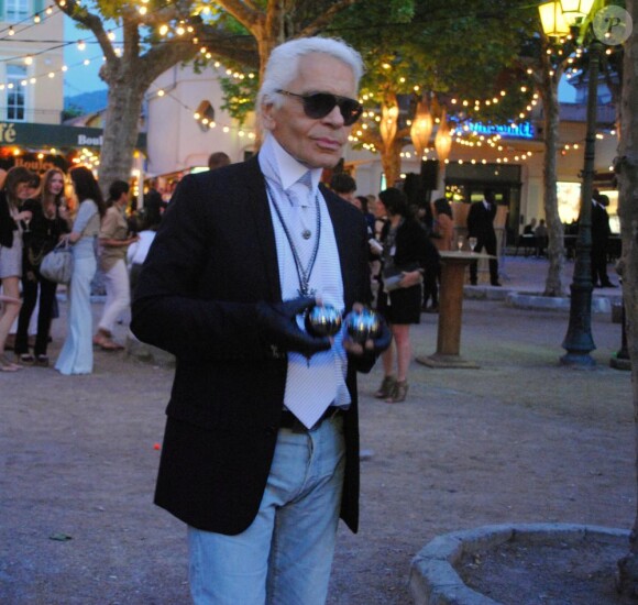 Karl Lagerfeld avec une paire de boules signées CHANEL. Le 10 mai 2010, place des Lices.