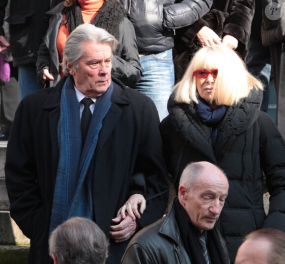 Alain Delon et Mireille Darc quittant l'église Saint-Roch à Paris où se sont déroulées les obsèques d'Annie Girardot le 4 mars 2011