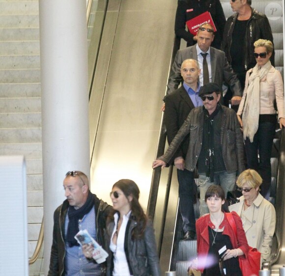 Johnny Hallyday et son épouse Laeticia arrivent en France à l'aéroport Roissy-Charles-de-Gaulle le 15 mars 2011. Leurs amis Jean-Claude Darmon et sa fiancée Hoda Roche (en bas à gauche) sont aussi du voyage