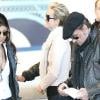 Johnny Hallyday et son épouse Laeticia arrivent en France à l'aéroport Roissy-Charles-de-Gaulle le 15 mars 2011. Leur amie Hoda Roche (à gauche) est aussi du voyage