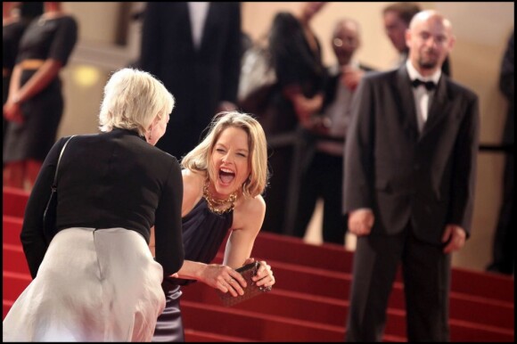 Jodie Foster rit face à une amie lors de la montée des marches du film Melancholia, à Cannes, le 18 mai 2011.