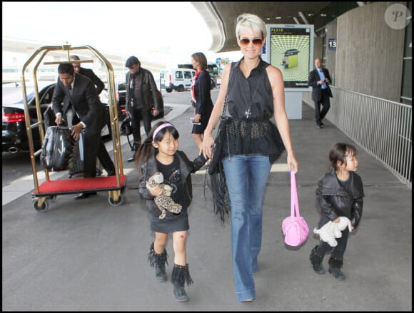 Laeticia Hallyday tenant ses filles Jade et Joy à l'aéroport de Roissy-Charles-de-Gaulle le 31 mai 2011