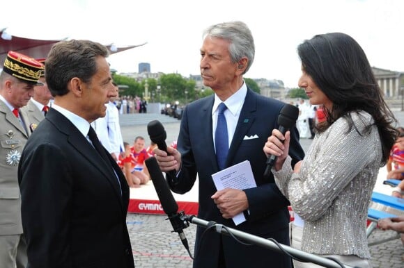 Nicolas Sarkozy face à Marie Drucker et Jean-Claude Narcy lors du défilé du 14 juillet 2011, à Paris.