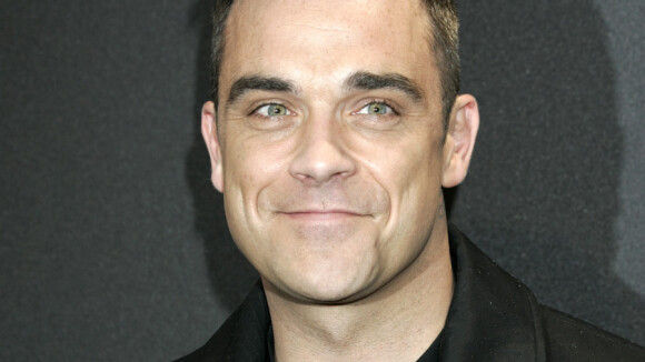 Robbie Williams, sobre et élégant, provoque la folie