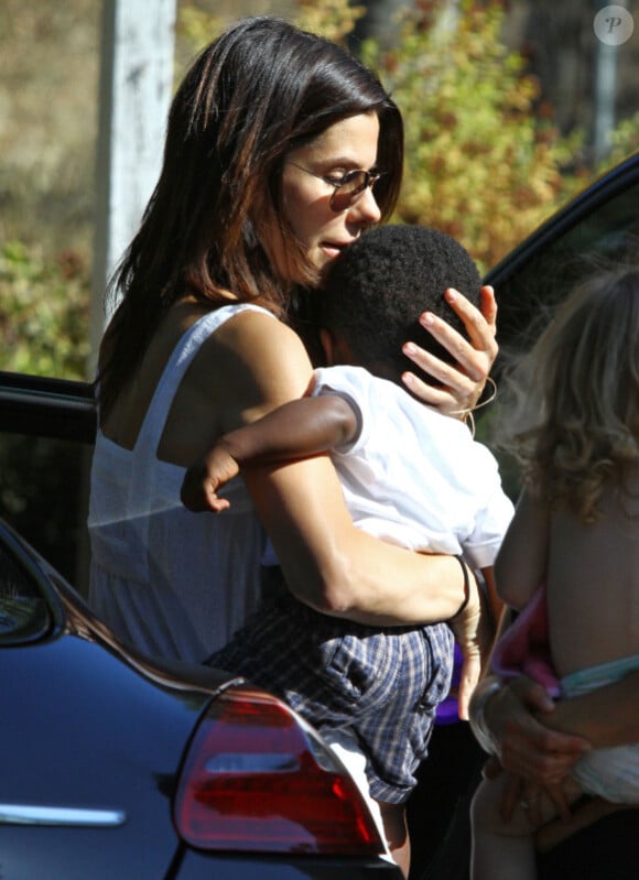 Sandra Bullock rentrant chez elle à Los Angeles le 29 août 2011 avec son petit Louis : elle ne manque pas de gestes tendres