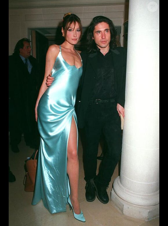 Carla Bruni affiche son magnifique port de tête et son corps de rêve dans une robe fendue aux côtés d'Arno Klarsfeld. Paris, 22 janvier 1995