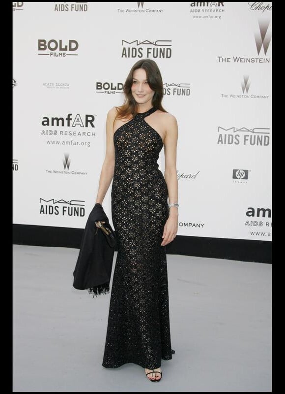 En soirée, Carla Bruni se veut toujours élégante. Ici, elle moule sa silhouette dans une ravissante robe noire et dorée. Cannes, 23 mai 2007