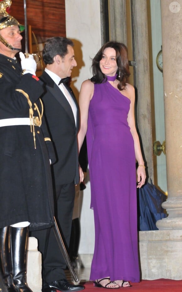 Pour son premier dîner officiel à l'Élysée, Carla Bruni-Sarkozy opte  pour une sublime robe asymétrique violette qui met en valeur sa  silhouette longiligne. Paris, 10 mars 2008