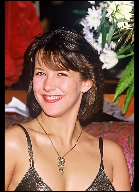 Sophie Marceau a coupé ses cheveux bruns pour leur donner un peu de volume. La jeune actrice est radieuse au naturel. 3 mars 1985