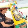 Jenson Button, hilare au volant de son tuk-tuk traditionnel le 27 octobre 2011 sur le circuit de Buddh en Inde