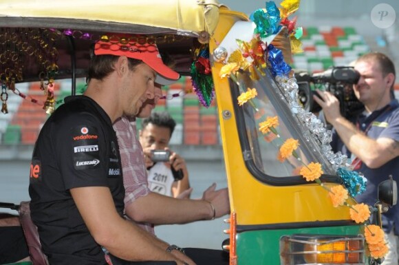 Jenson Button tente de comprendre le fonctionnement de son tuk-tuk le 27 octobre 2011 sur le circuit de Buddh en Inde