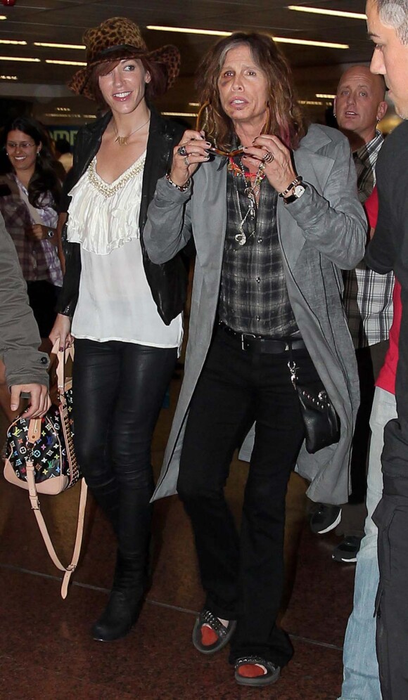 Steven Tyler, toujours bien amoché, et sa petite-amie Erin Brady arrivent à l'aéroport de Sao Paulo, le 30 octobre 2011.