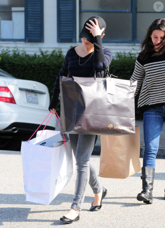 Mila Kunis, cachée par sa casquette, sort d'une séance shopping fructueuse. Beverly Hills, le 15 novembre 2011.