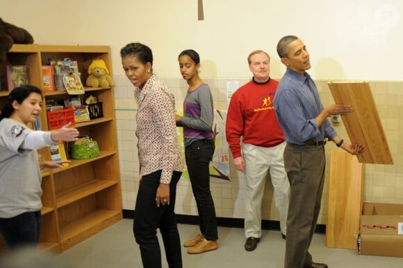 Barack, Malia et Michelle Obama participent à la construction d'une librairie lors d'une journée de charité dans un centre d'éducation à Washington. Le 16 janvier 2011