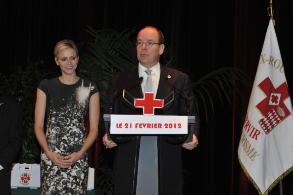 Le prince Albert II de Monaco pendant son discours et sa femme la princesse Charlene lors de la cérémonie de la Croix-Rouge, à Monaco, le 21 février 2012