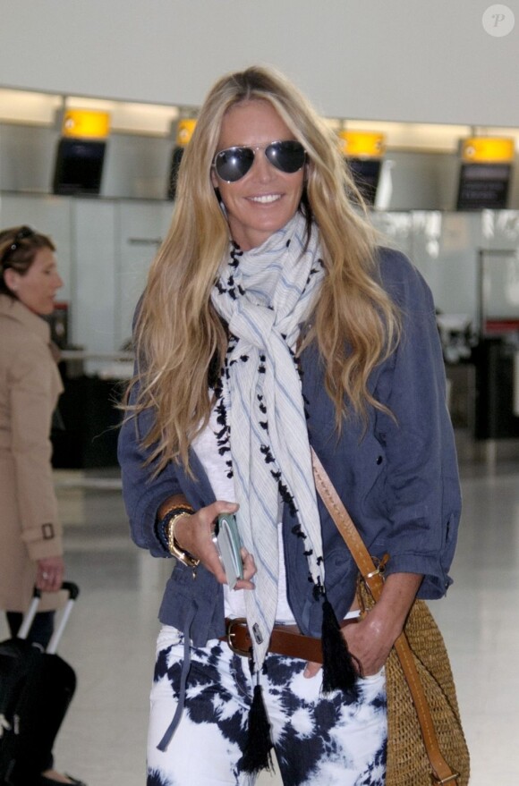 Elle Macpherson, stylée à l'aéroport d'Heathrow, s'apprête à embarquer direction l'Inde. Londres, le 13 avril 2012.