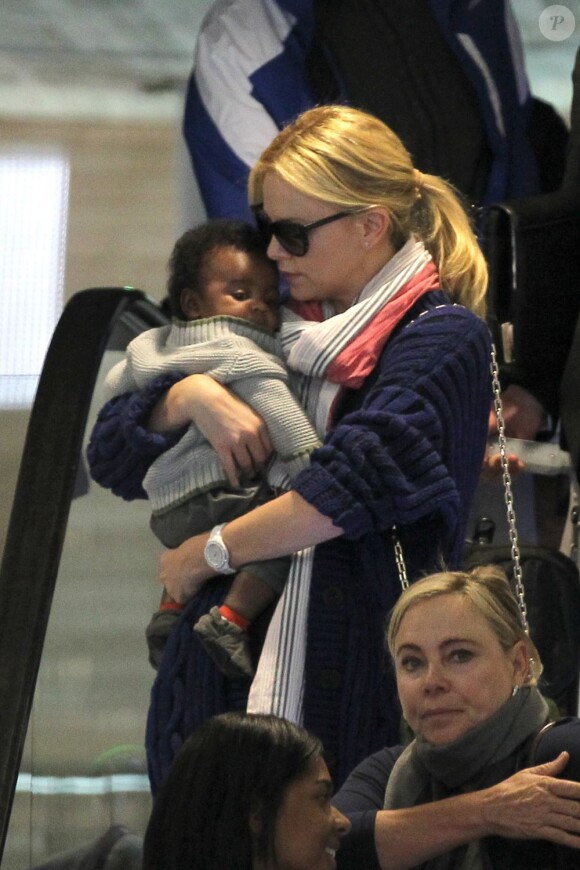 Très maternelle, Charlize Theron présente son fils Jackson, à l'aéroport de Paris Roissy, le 8 mai 2012