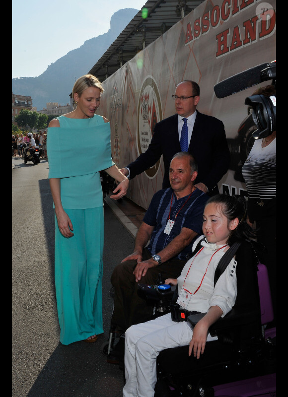 Le prince Albert et Charlene dans une tenue très particulière le 26 mai 2012 dans le paddock auprès de personnes handicapées à l'occasion du Grand Prix de Monaco