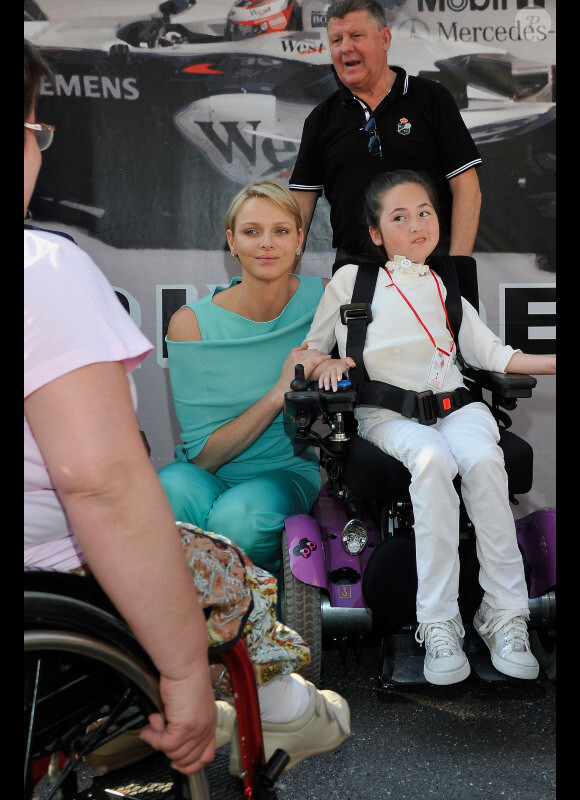 Le prince Albert et Charlene le 26 mai 2012 dans le paddock à la rencontre de personnes hadicapées à l'occasion du Grand Prix de Monaco