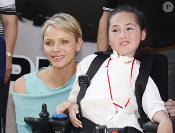 La princesse Charlene pose au côté d'une jeune fille handicapée rencontrée dans le paddock du Grand Prix de Monaco le 26 mai 2012