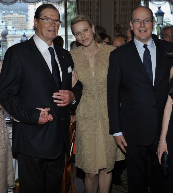 Albert et Charlene de Monaco avec Roger Moore au dîner du Club des Ambassadeurs, organisé à l'Hôtel de Paris à Monaco, le 12 juin 2012.
