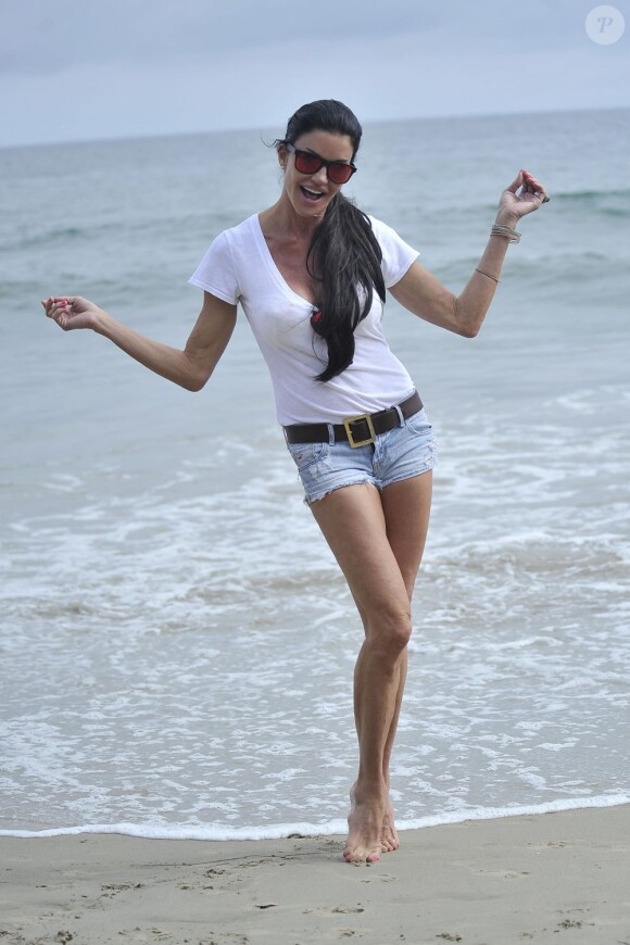 En plein show, Janice Dickinson fait son yoga sur la plage de Malibu le 4 juillet 2012