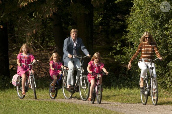 Pour les photographes, les royaux ont simulé une balade à vélo. Le prince Willem-Alexander et le princesse Maxima des Pays-Bas, comme chaque année, ont pris la pose avec leurs filles les princesses Catharaina-Amalia, Alexia et Ariane, désormais âgées de 8, 7 et 5 ans, pour fêter l'arrivée des vacances d'été. Le 7 juillet 2012, la séance photo a eu lieu dans le parc de la résidence familiale à Wassenaar, la villa Eikenhorst.