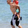 Victor Valdés et son petit Dylan en sortant de l'eau sur la plage de Sardaigne le 19 juillet 2012