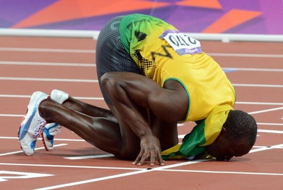 Prostré, mais c'est bien lui le dieu. Usain Bolt a conservé en 19"32 sa couronne olympique sur 200m aux Jeux de Londres le 9 août 2012. L'Eclair jamaïcain est le premier athlète à défendre avec succès deux médailles d'or olympiques (100 et 200m) sur deux olympiades consécutives. Il est le plus grand sprinteur de tous les temps. Une légende.