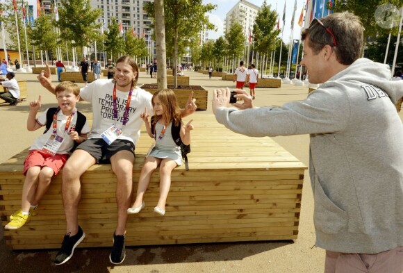 Le prince Frederik de Danemark prend en photo ses enfants Christian et Isabella avec le handballeur Mikkel Hansen, le 9 août 2012 au village olympique des JO de Londres, à Stratford.