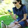 Absorbée par son iPhone, Emmy Rossum passe du bon temps dans un parc de Los Angeles. Le 15 août 2012