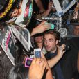 Robert Pattinson signe des autographes à ses fans devant les studios de la chaîne ABC où se tournait le Jimmy Kimmel Live, le mercredi 22 août 2012 à New York.
