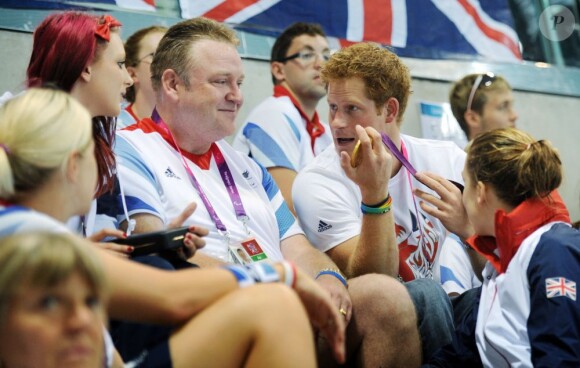 Ambiance nettement plus détendue dans les gradins de l'Aquatics Center. Le prince Harry est accueilli par les nageuses du Team GB aux Jeux paralympiques de Londres, le 4 septembre 2012.