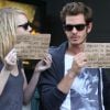 Emma Stone et Andrew Garfield brandissent une petite pancarte faisant la promotion de deux associations qu'ils défendent, à New York, le 15 septembre 2012.