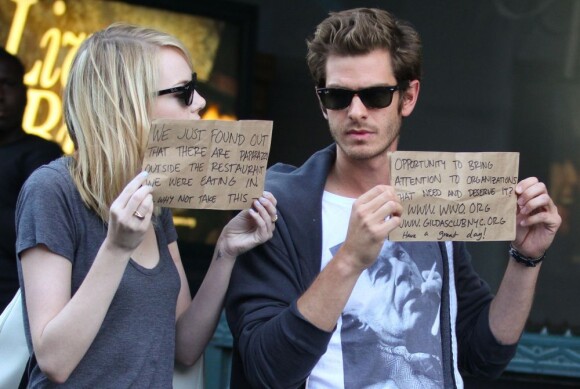 Emma Stone et Andrew Garfield brandissent une petite pancarte faisant la promotion de deux associations qu'ils défendent, à New York, le 15 septembre 2012.