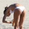 Exclusif - Alessandra Ambrosio, en bikini blanc, se protège du soleil durant son après-midi à la plage. Malibu, le 14 octobre 2012.
