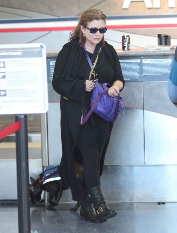L'actrice Carrie Fisher accompagnée de son chien à l'aéroport de Los Angeles, le 3 novembre 2012.