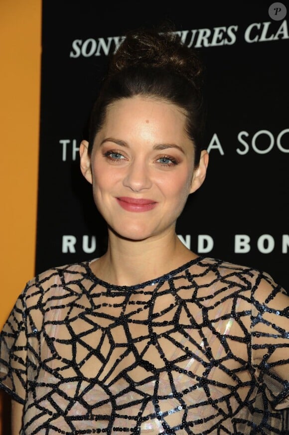 Marion Cotillard souriante dans une robe Dior légérement transparente pour l'avant-première du film De rouille et d'os, le 8 novembre 2012.