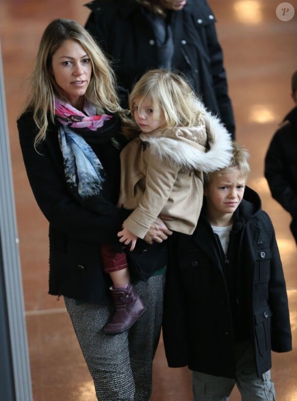 Christine Baumgartner porte Grace Avery dans ses bras, accompagné de Cayden juste derrière, à l'aéroport Roissy-Charles-de-Gaulle, le 15 janvier 2013.