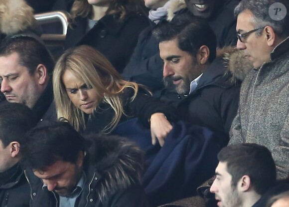 Cécile de Ménibus et Ary Abittan tentent de se réchauffer lors du match entre le Paris Saint-Germain et Toulouse le 23 janvier 2013 à Paris