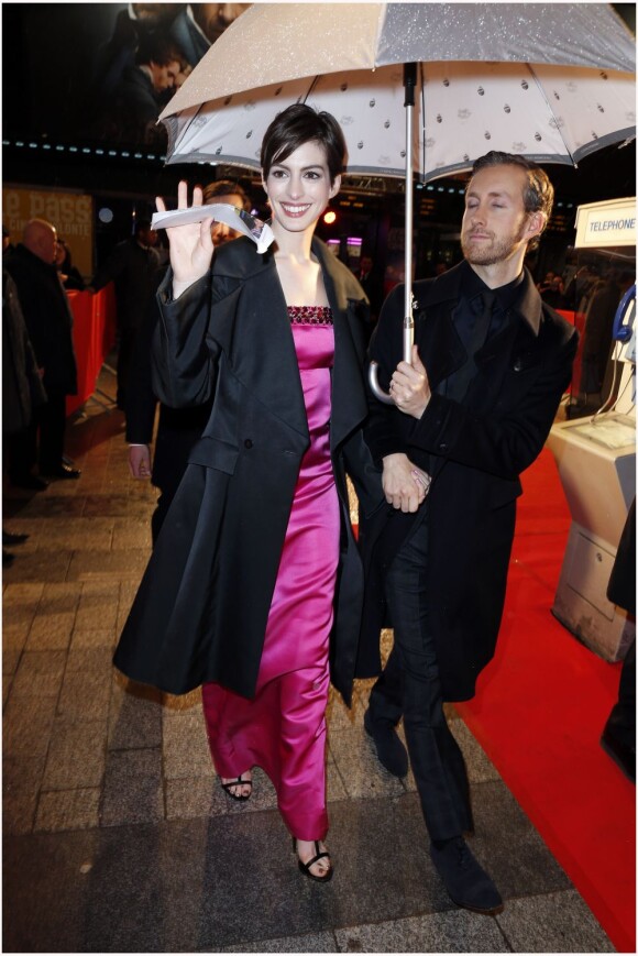 Anne Hathaway et son mari Adam Shulman sous la pluie  lors de l'avant-première du film Les Misérables à Paris sur les Champs-Elysées le 6 février 2013