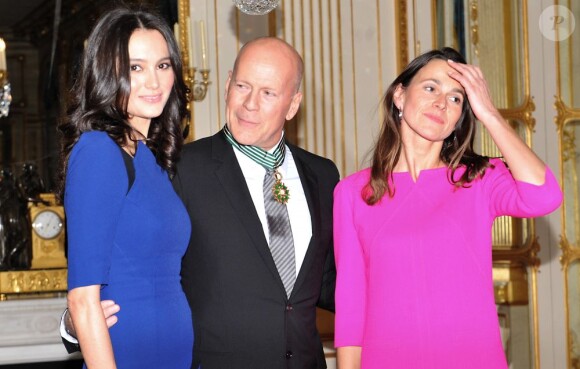 Bruce Willis entre de sa femme Emma Heming à gauche et de la ministre de la Culture Aurélie Filippetti à Paris le 11 février 2013.