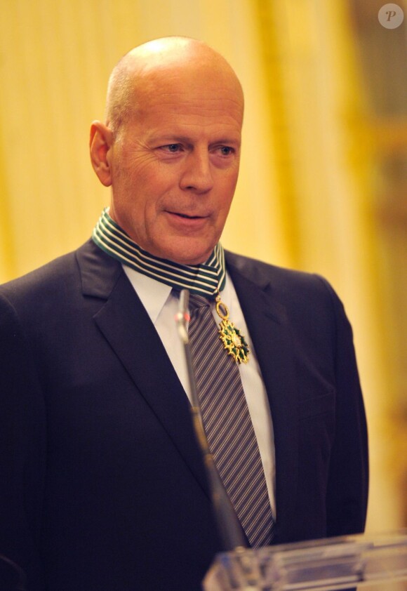 Bruce Willis et l'insigne de commandeur de l'ordre des Arts et des Lettres à Paris, le 11 février 2013.